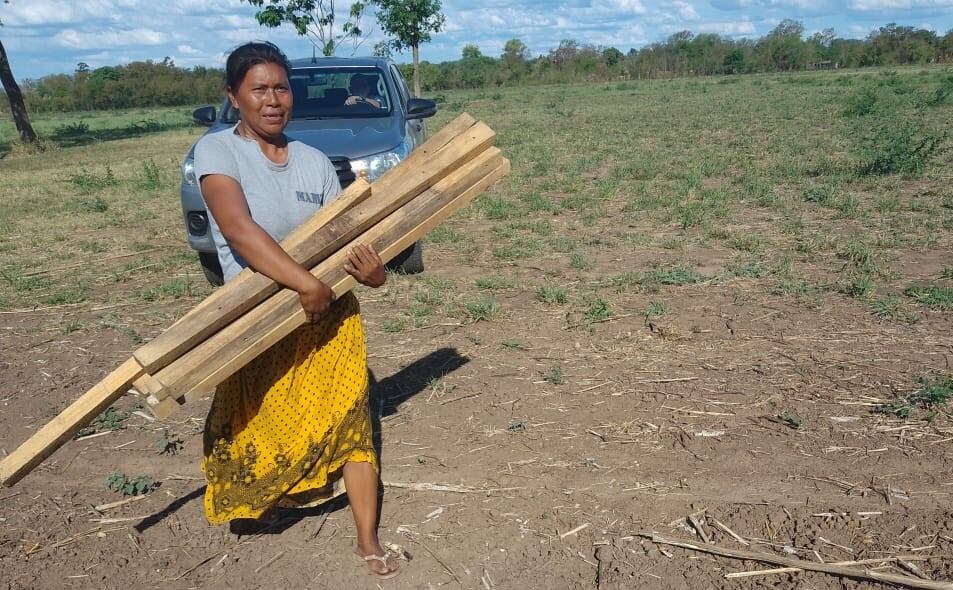 Una mujer retira parte del alambrado. Detrás, el conductor que atacó a dos miembros de la comunidad.