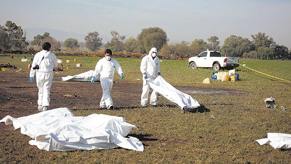 Expertos forenses realizan trabajos de campo en el lugar de la explosión del ducto de combustible de Pemex.