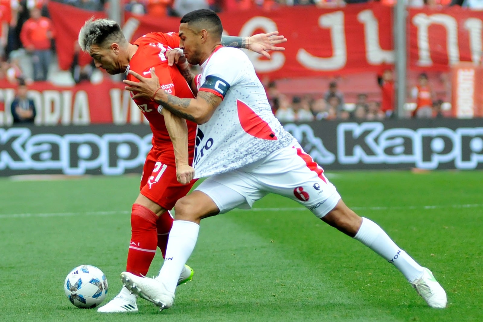 Julio Buffarini toma de la camiseta a Alarcón