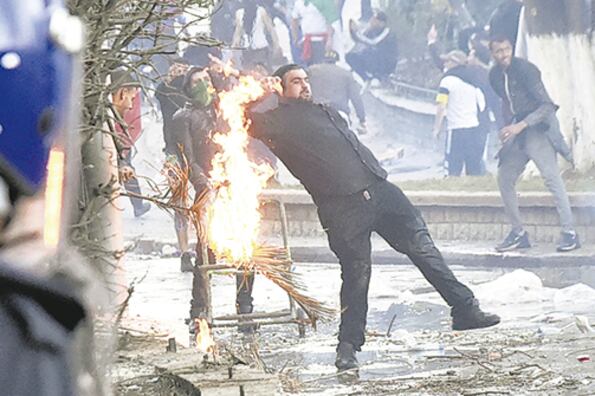Miembros de las fuerzas de seguridad se enfrentan con manifestantes en la capital argelina.