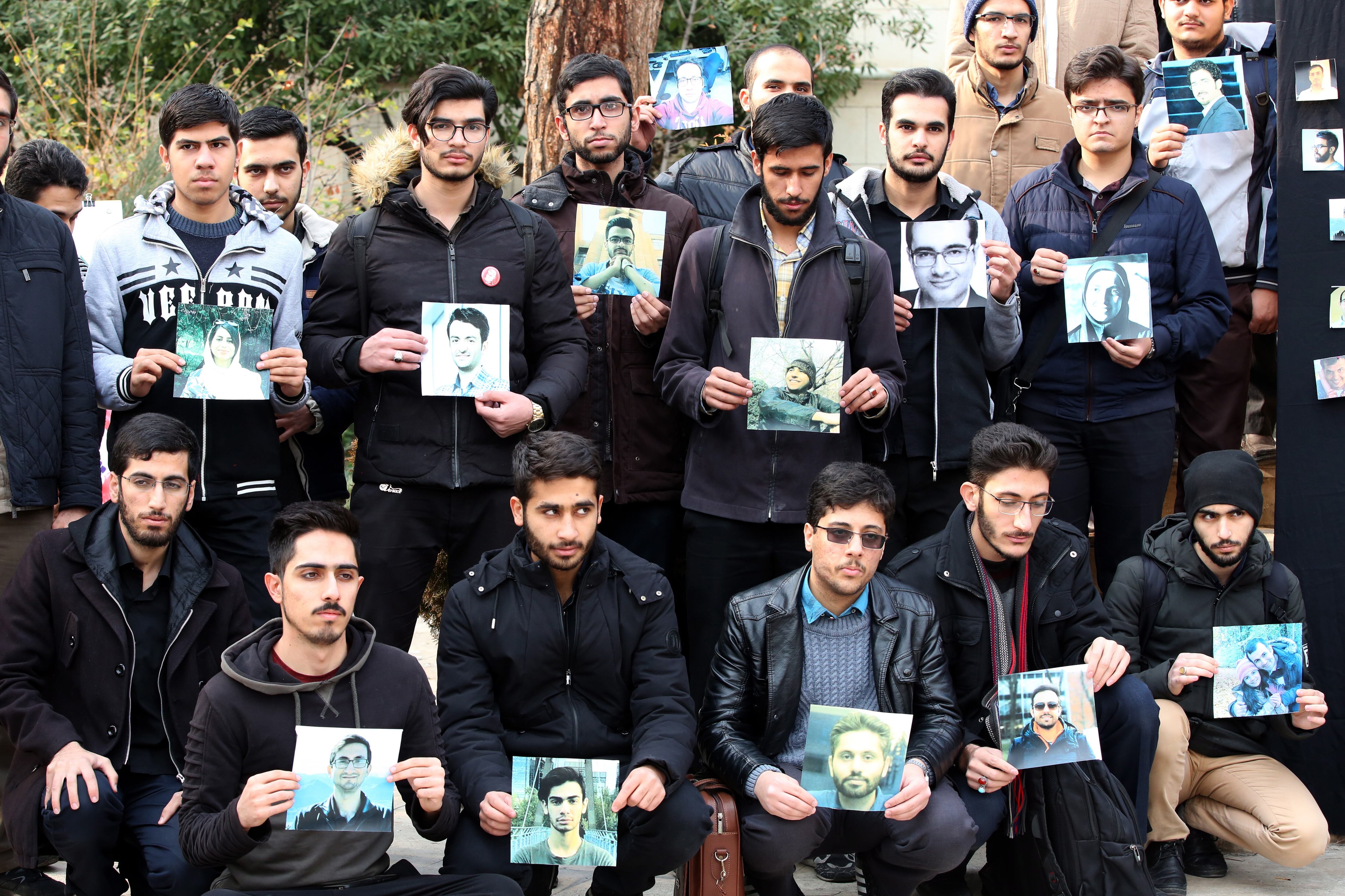 Varios estudiantes posan con fotos de las víctimas del derribo del avión ucraniano por error. 