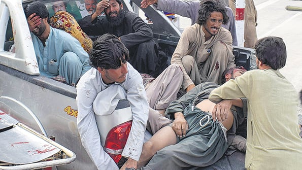 Un grupo de personas carga a una de las víctimas del atentado en Quetta.