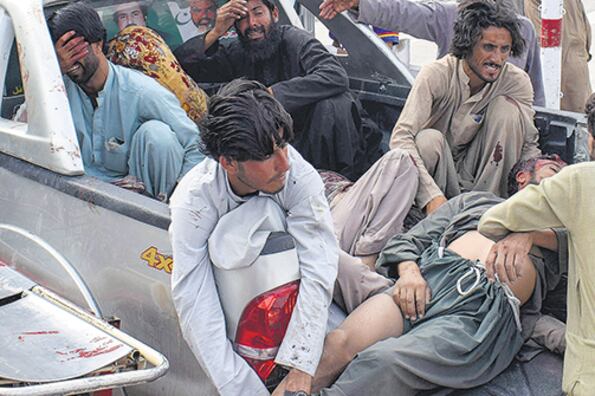 Un grupo de personas carga a una de las víctimas del atentado en Quetta.
