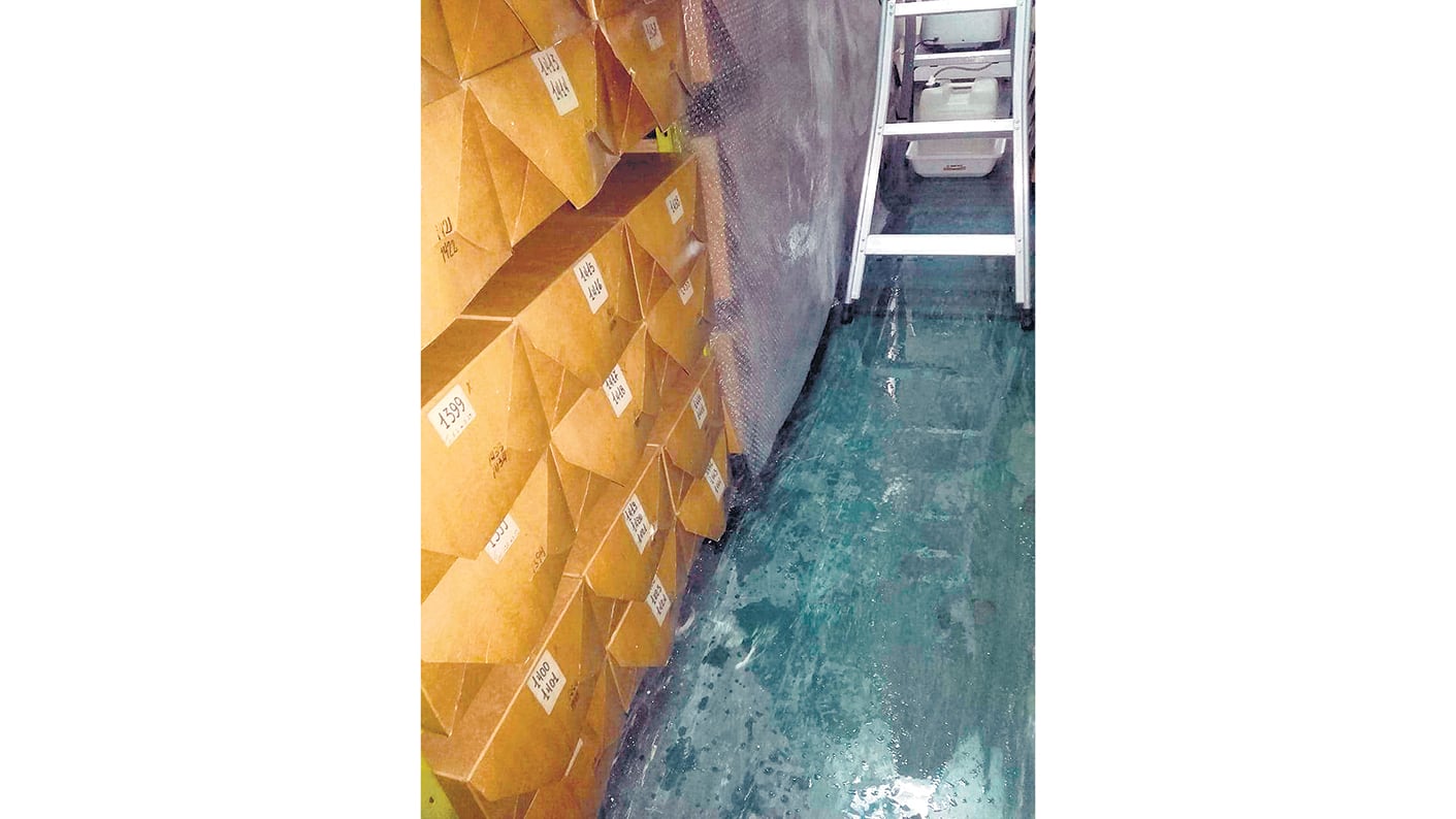 Los empleados pusieron plástico para que el agua no siguiera afectando las cajas con fotos.