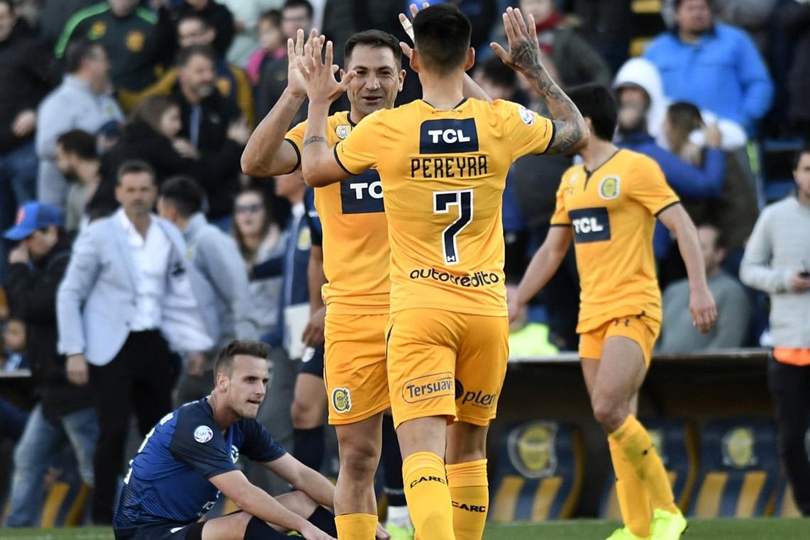 Pereyra, uno de los pocos juveniles utilizados por Cocca, se saluda con Rinaudo, mediocampista de mil batallas.