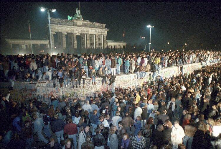 Miles de alemanes en el Muro, frente a la Puerta de Brandeburgo, la noche del 9 de noviembre de 1989.