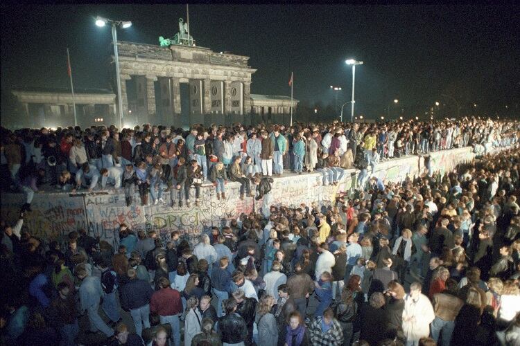 Miles de alemanes en el Muro, frente a la Puerta de Brandeburgo, la noche del 9 de noviembre de 1989.
