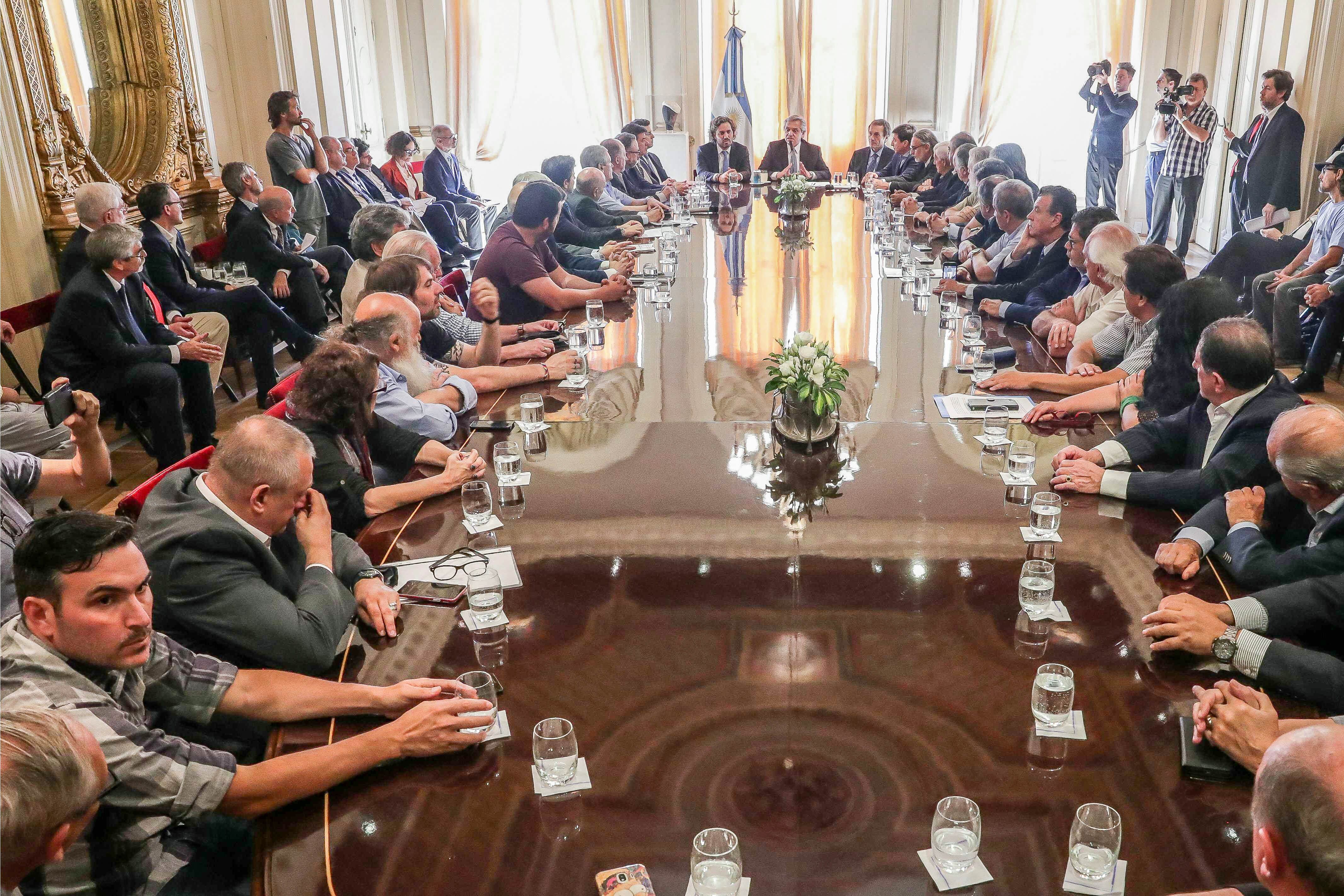 La larga mesa del salon Eva Perón sirvió para ubicar a todos los firmantes del acuerdo.