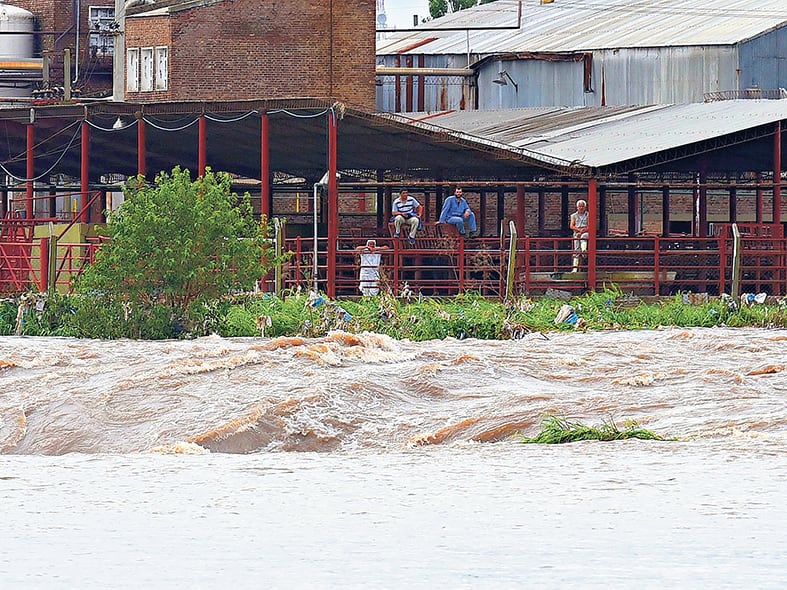El agua arrasa con todo mientras los pobladores esperan, absortos, que las fuerzas naturales se calmen, rezando o esperando ayuda.
