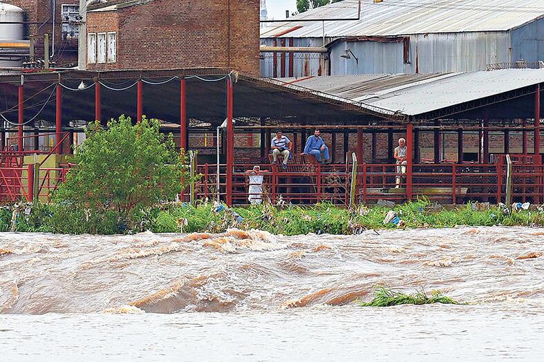 El agua arrasa con todo mientras los pobladores esperan, absortos, que las fuerzas naturales se calmen, rezando o esperando ayuda.