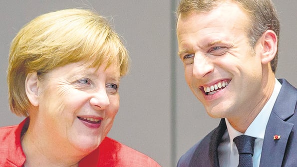 Merkel y Macron se saludan en la cumbre de Bruselas.