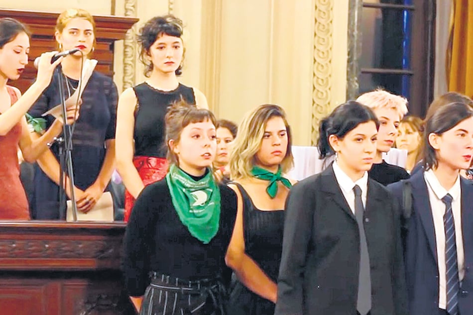 El acto: Ema Graña (arriba, en el centro), Zoe Taricco (adelante, con pañuelo verde al cuello) y Cata Gobelli, de corbata a su derecha.