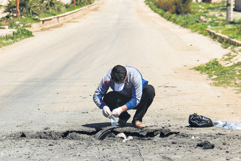 Un especialista sirio extrae muestras en el lugar donde sucedió el ataque.