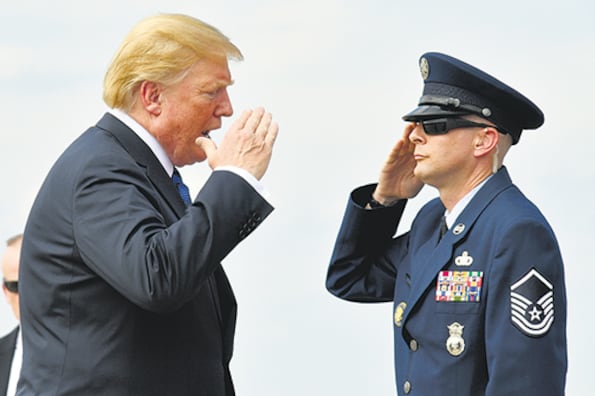 Trump saluda a un escolta en la base aérea Andrews antes de abordar el avión presidencial.