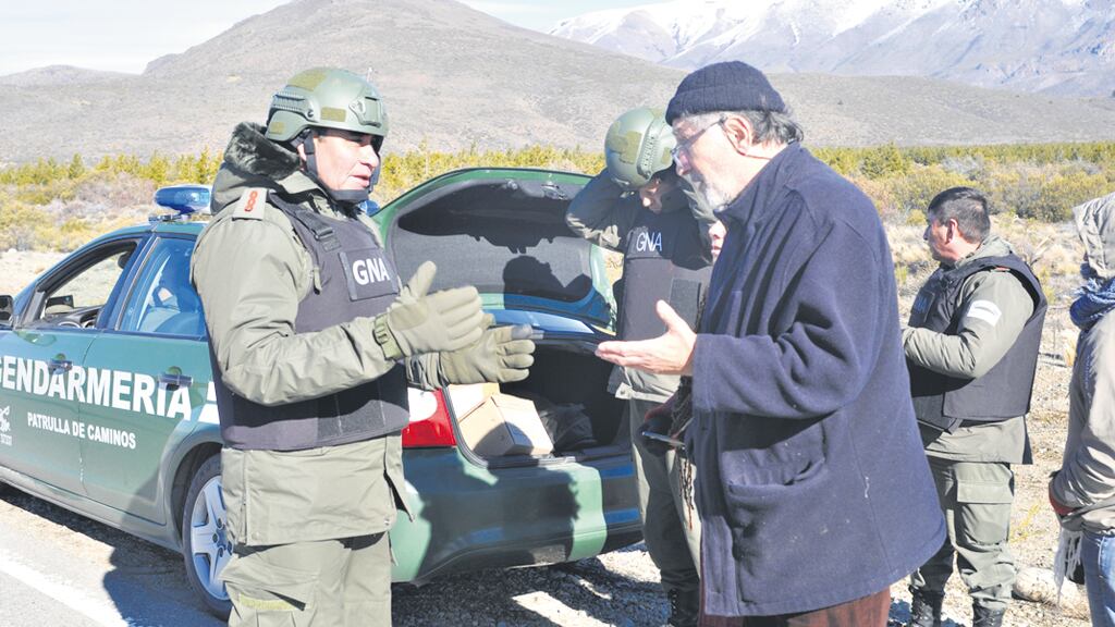 El civil, de lentes y gorro de lana, es Julio Saquero, interpelando a uno de los gendarmes desplegados en la zona.