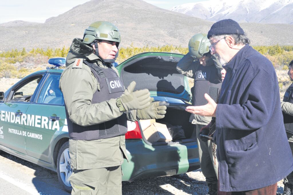 El civil, de lentes y gorro de lana, es Julio Saquero, interpelando a uno de los gendarmes desplegados en la zona.