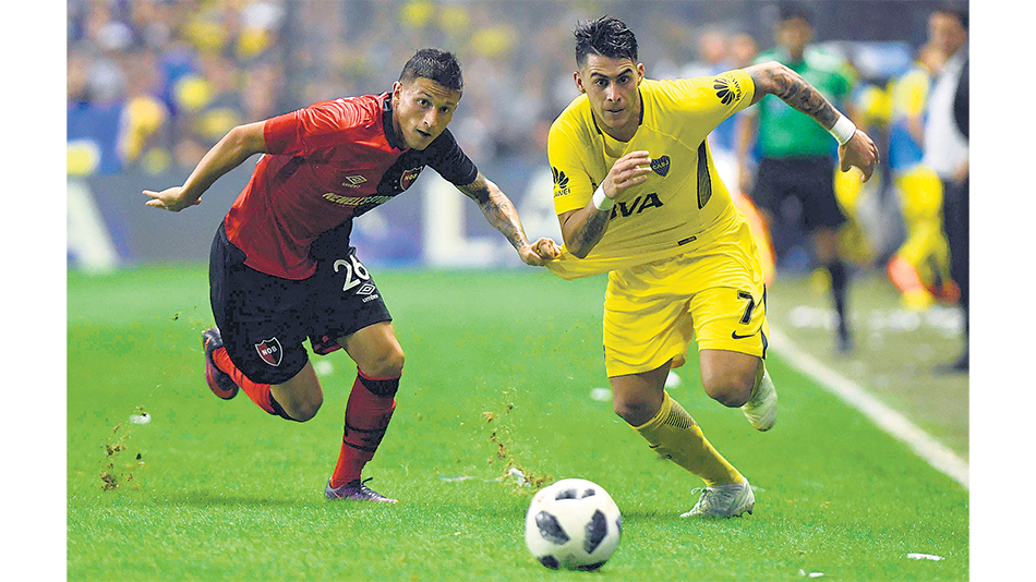 Pegado a la raya, Pavón se lleva la pelota ante la infructuosa marca de Fértoli.
