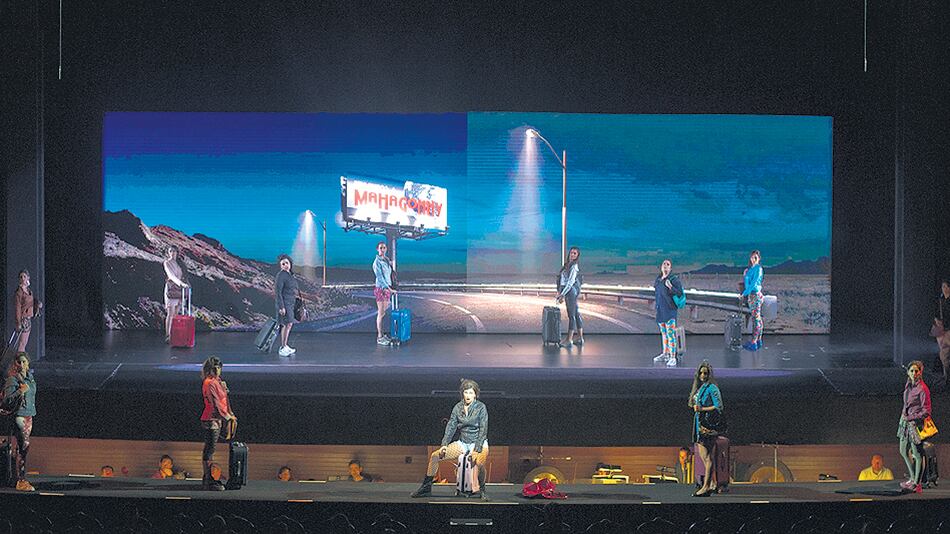 Lombardero recupera en esta puesta la idea de los carteles y proyecciones que estaban en el original.