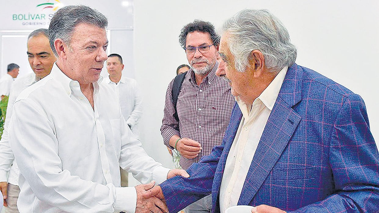 Santos saluda a Mujica en presencia de Pastor Alape, uno de los líderes de la ex guerrilla.