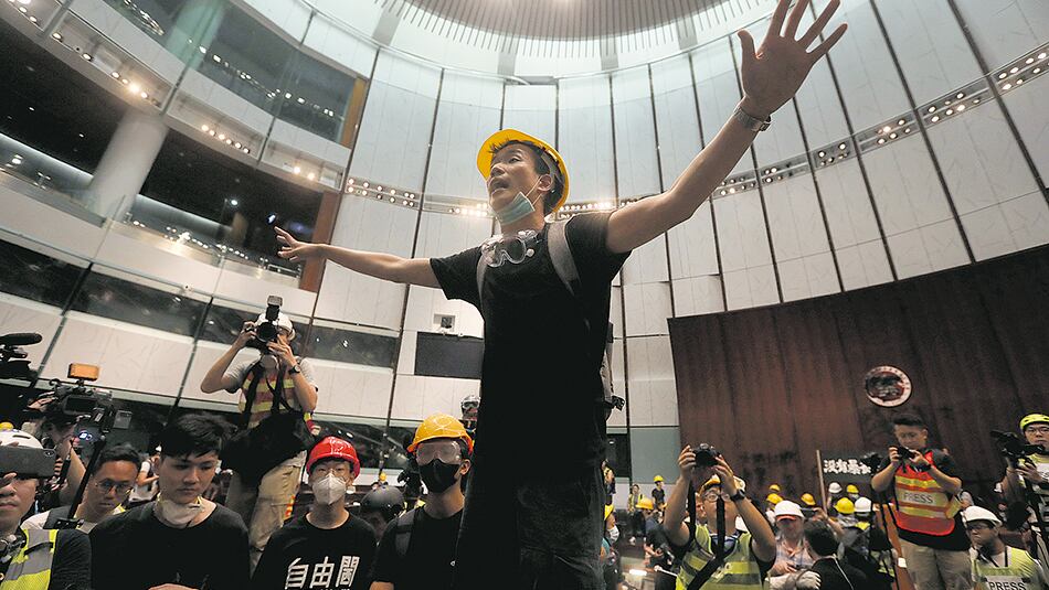 Manifestantes gesticulan después de irrumpir en el Parlamento de Hong Kong.