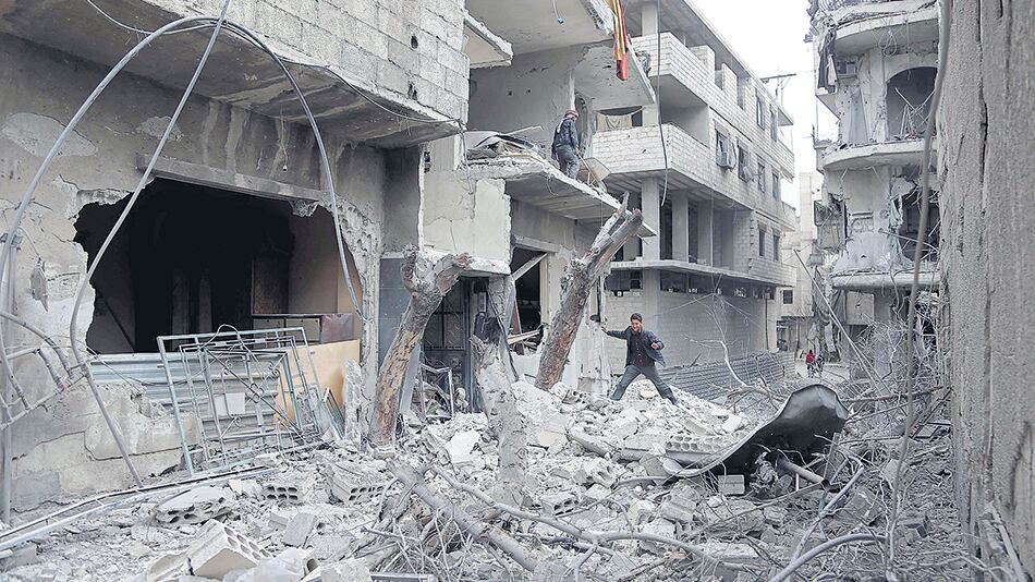 Un joven sirio aparece entre escombros en Hamouria, Guta Oriental.