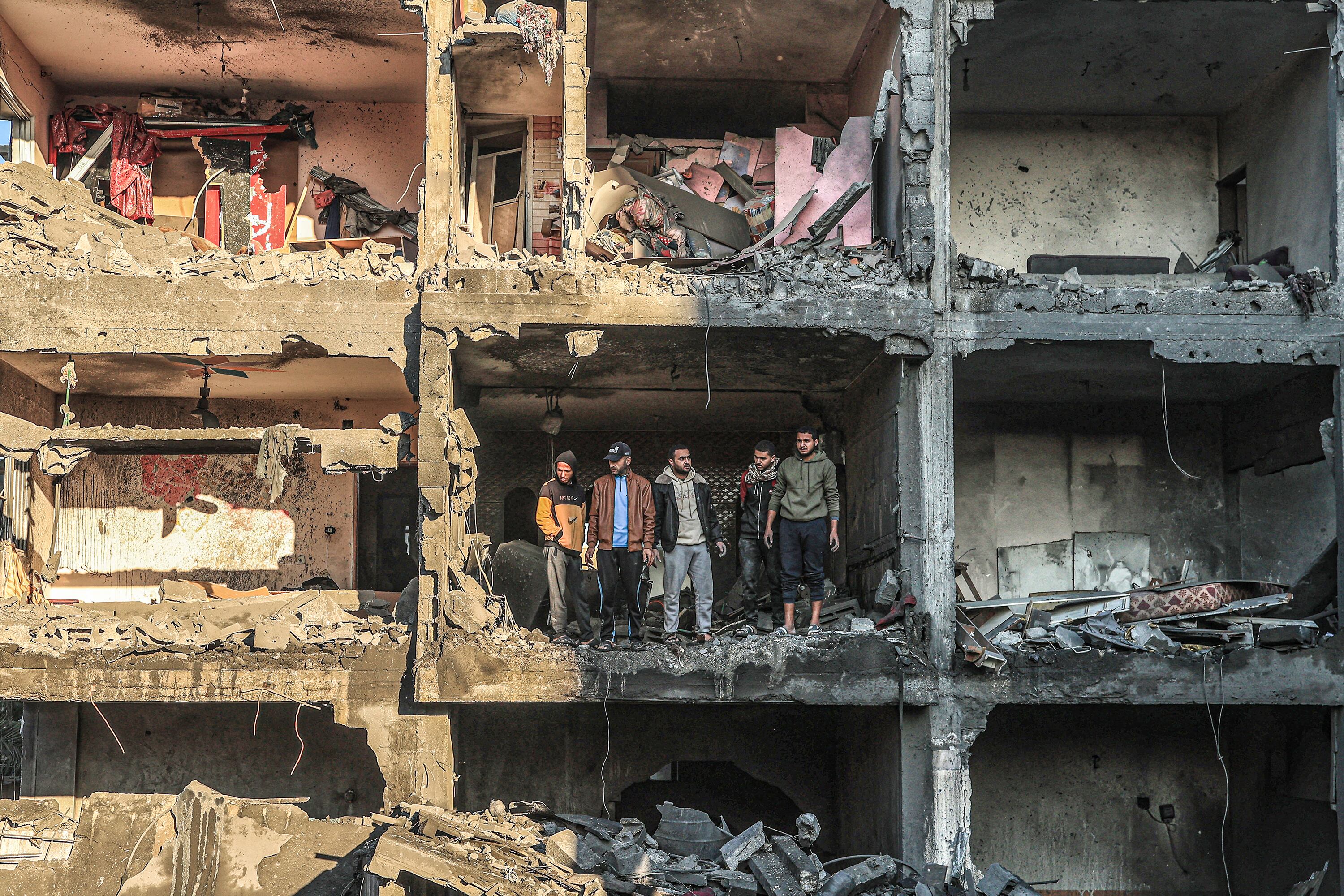 Palestinos inspeccionan un edificio semi destruido en Rafah, sur de Gaza.