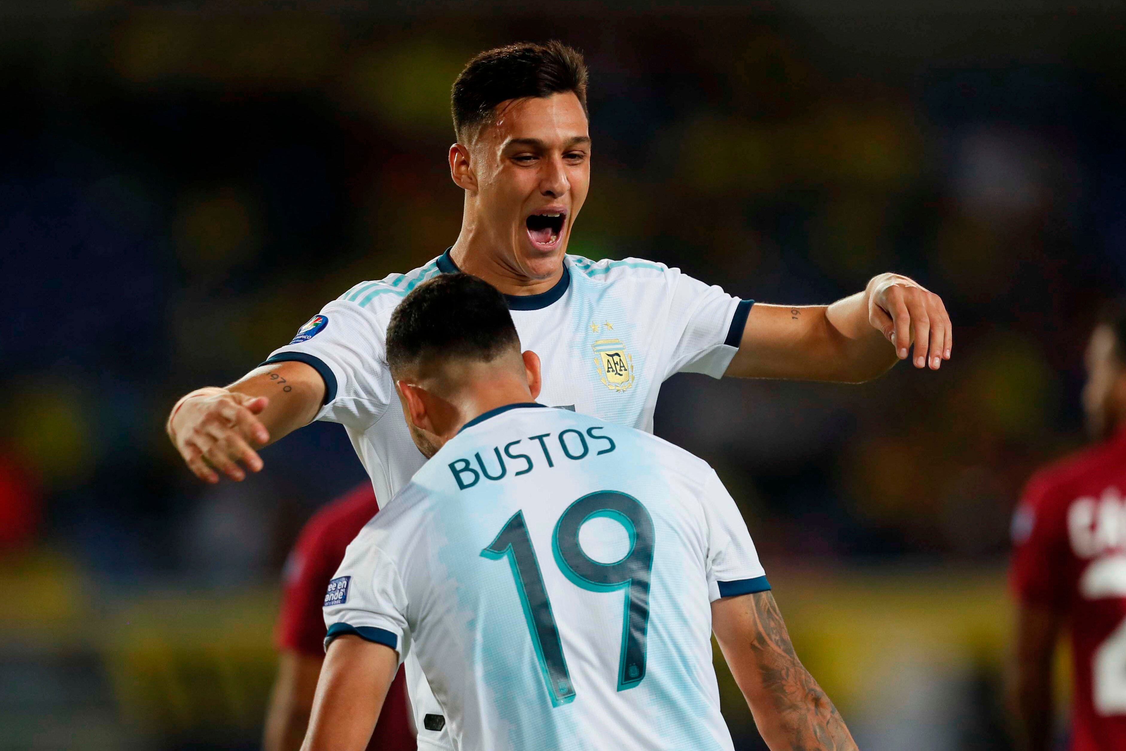 Bustos festeja con Colombo el empate. Argentina lo dio vuelta y goleó 4-1 a Venezuela.