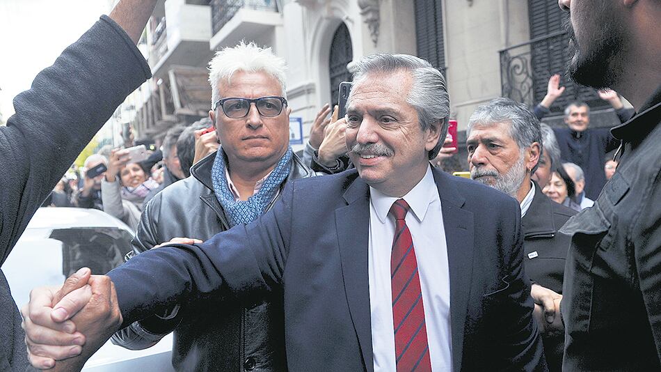Alberto Fernández saluda a la gente que lo esperaba a la salida del Instituto Patria, un día después del triunfo electoral.