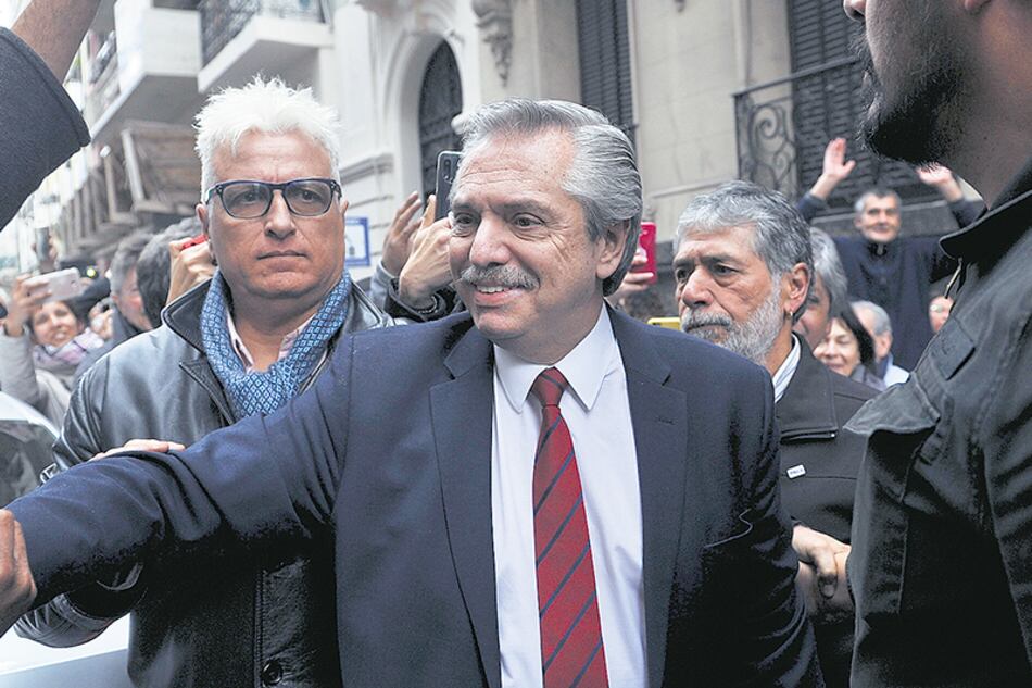 Alberto Fernández saluda a la gente que lo esperaba a la salida del Instituto Patria, un día después del triunfo electoral.