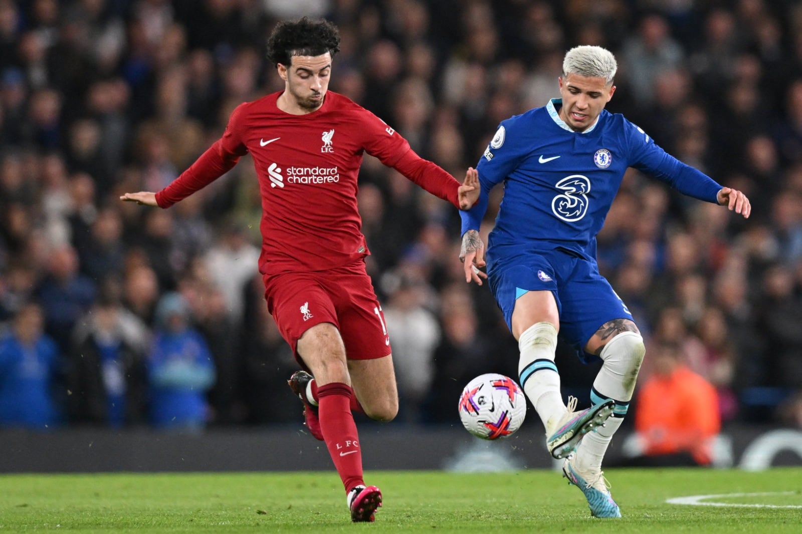 Fernández disputa la pelota con Salah