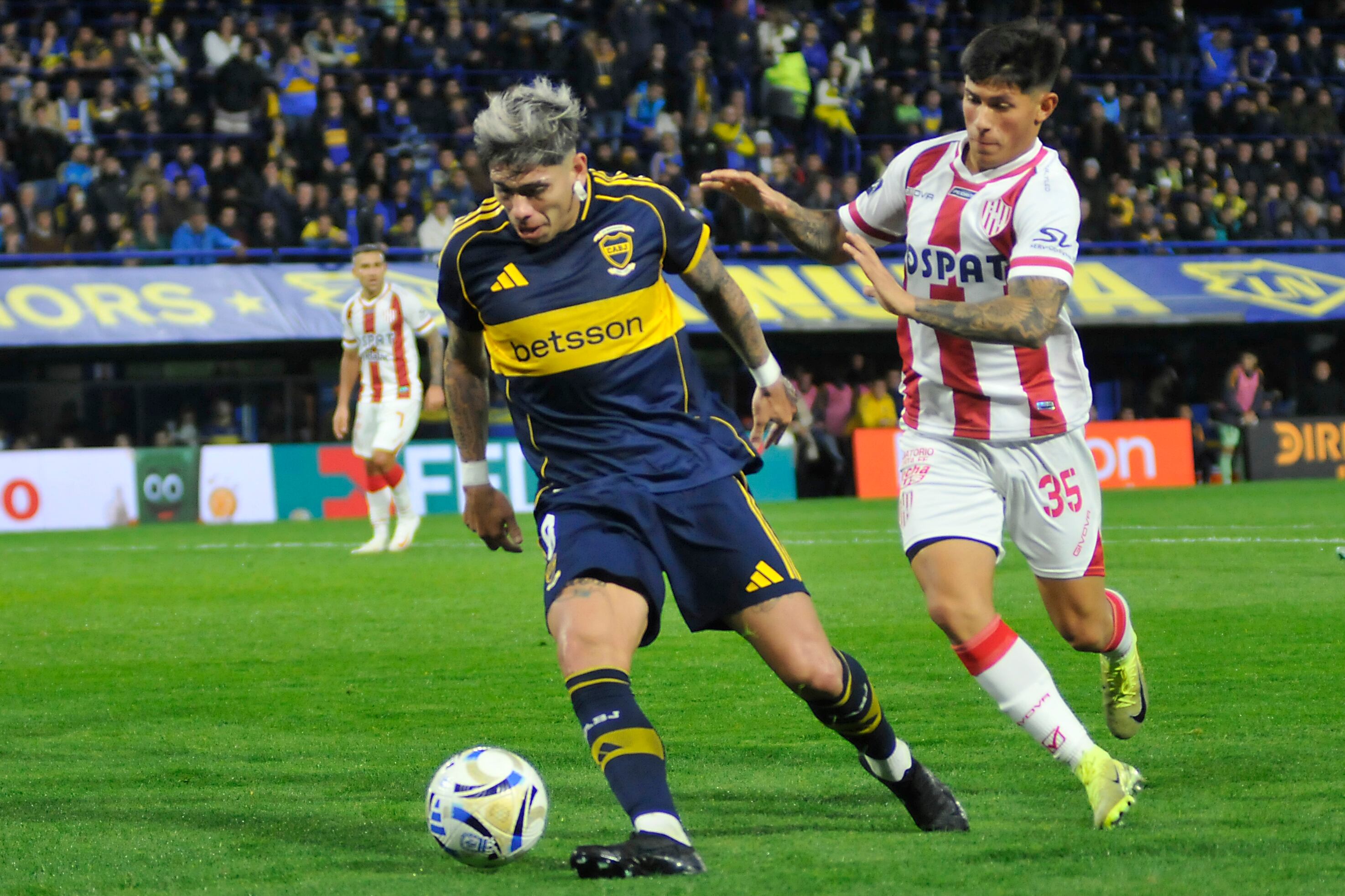 Carlos Palacios lleva la pelota ante la marca de Vargas