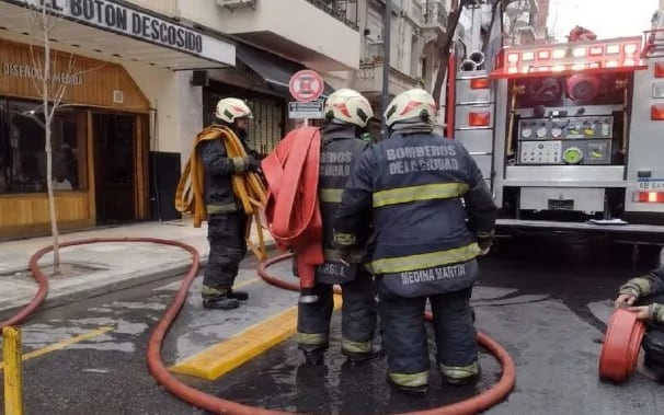 Los bomberos en la entrada del edificio que se incendió.