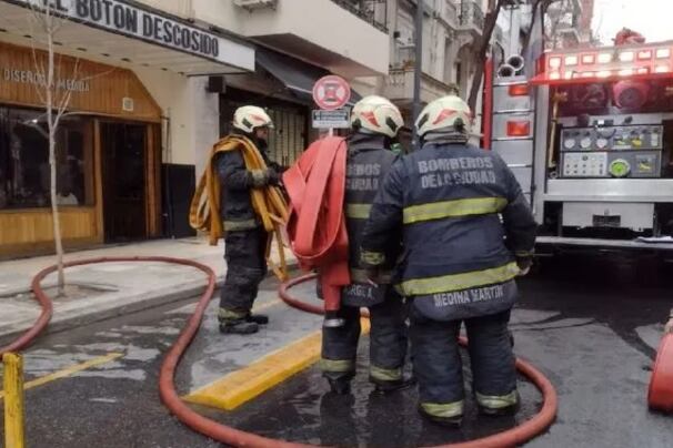 Los bomberos en la entrada del edificio que se incendió.