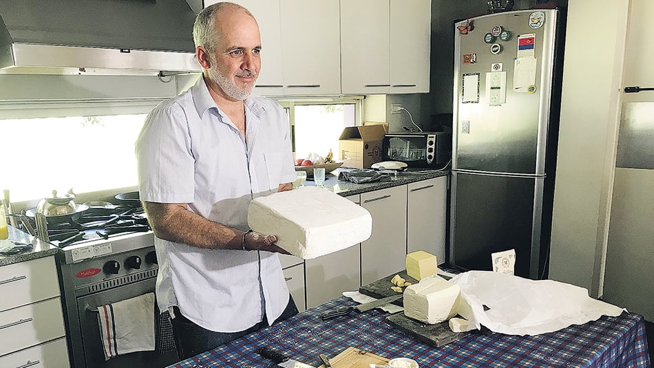 Una horma de cuartirolo y, en la mesa, feta rallado.