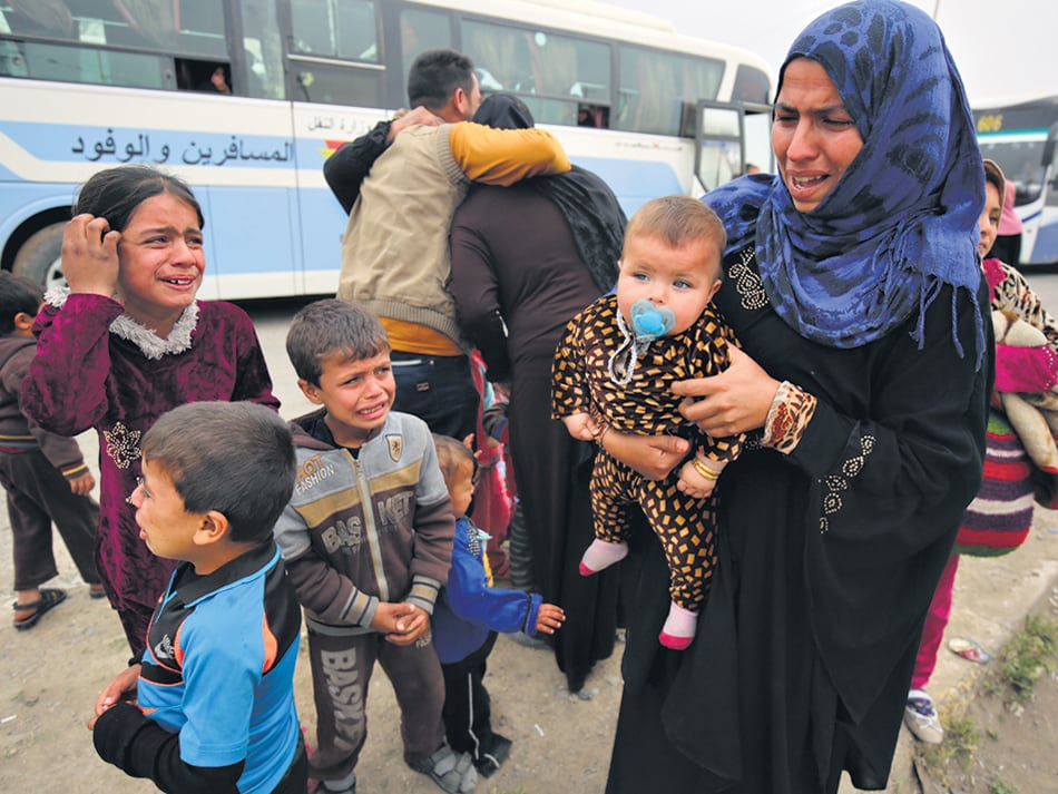 Una mujer con sus hijos llora la muerte de su marido a manos del EI. 