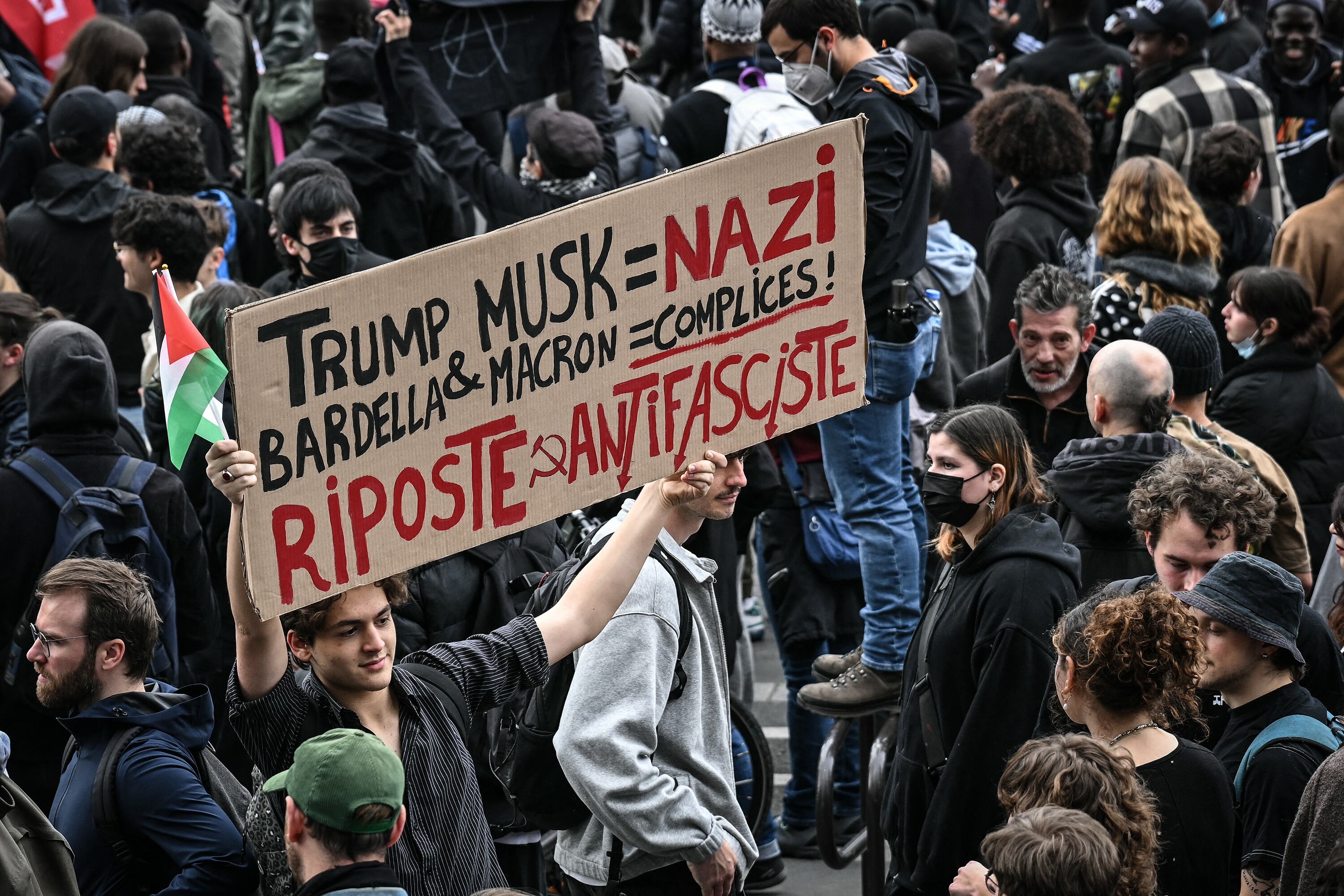 Un manifestante sostiene un cartel tildando de nazis a Trump y Musk en París.