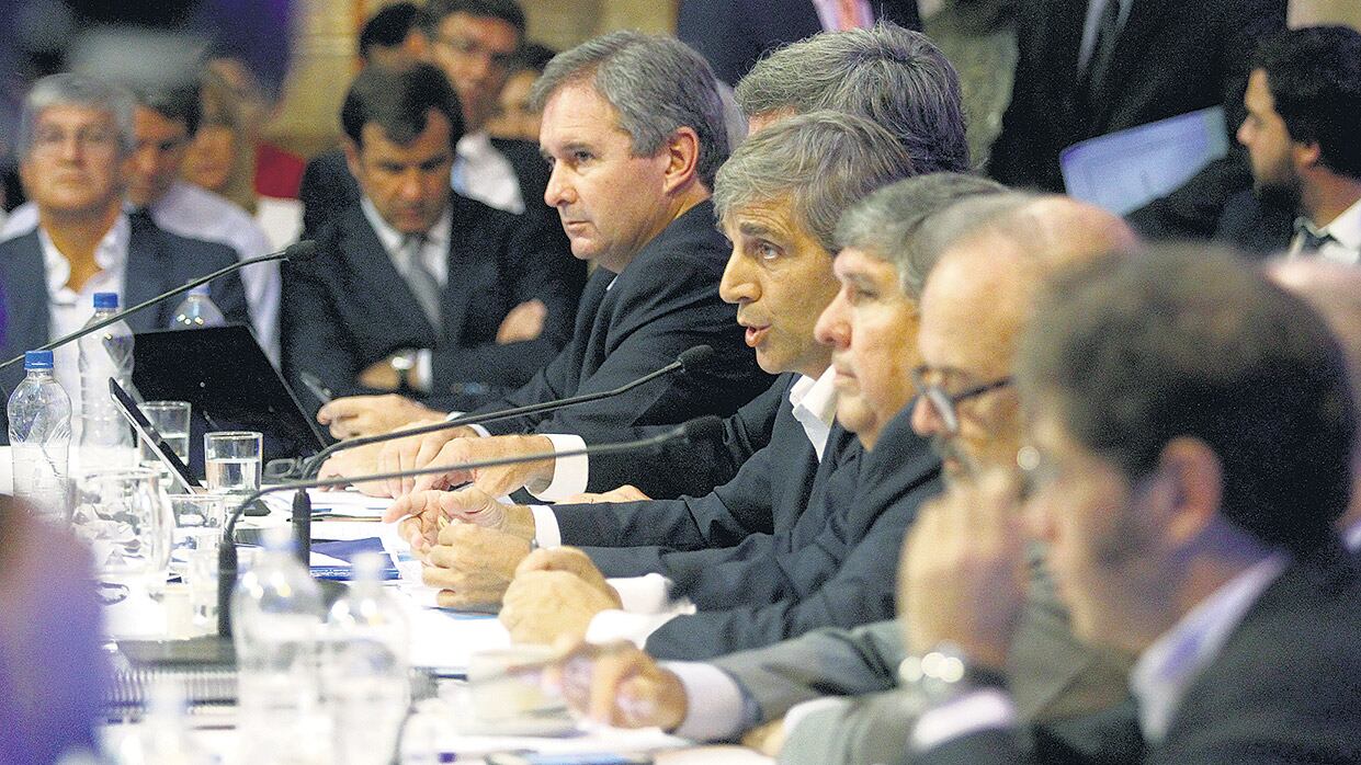 El ministro Luis Caputo, flanqueado por el titular de la comisión bicameral, el peronista José Mayans (Formosa).