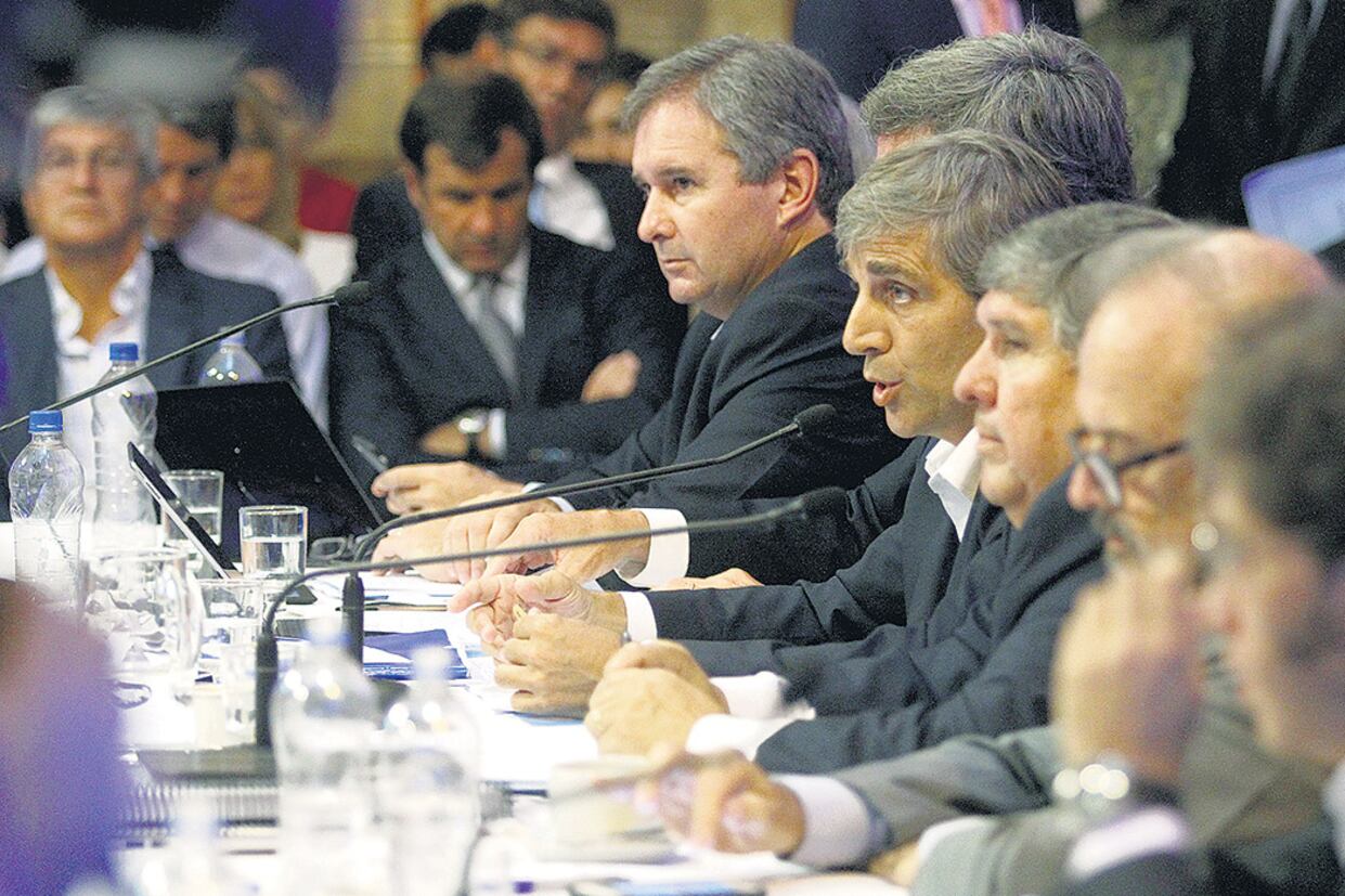 El ministro Luis Caputo, flanqueado por el titular de la comisión bicameral, el peronista José Mayans (Formosa).