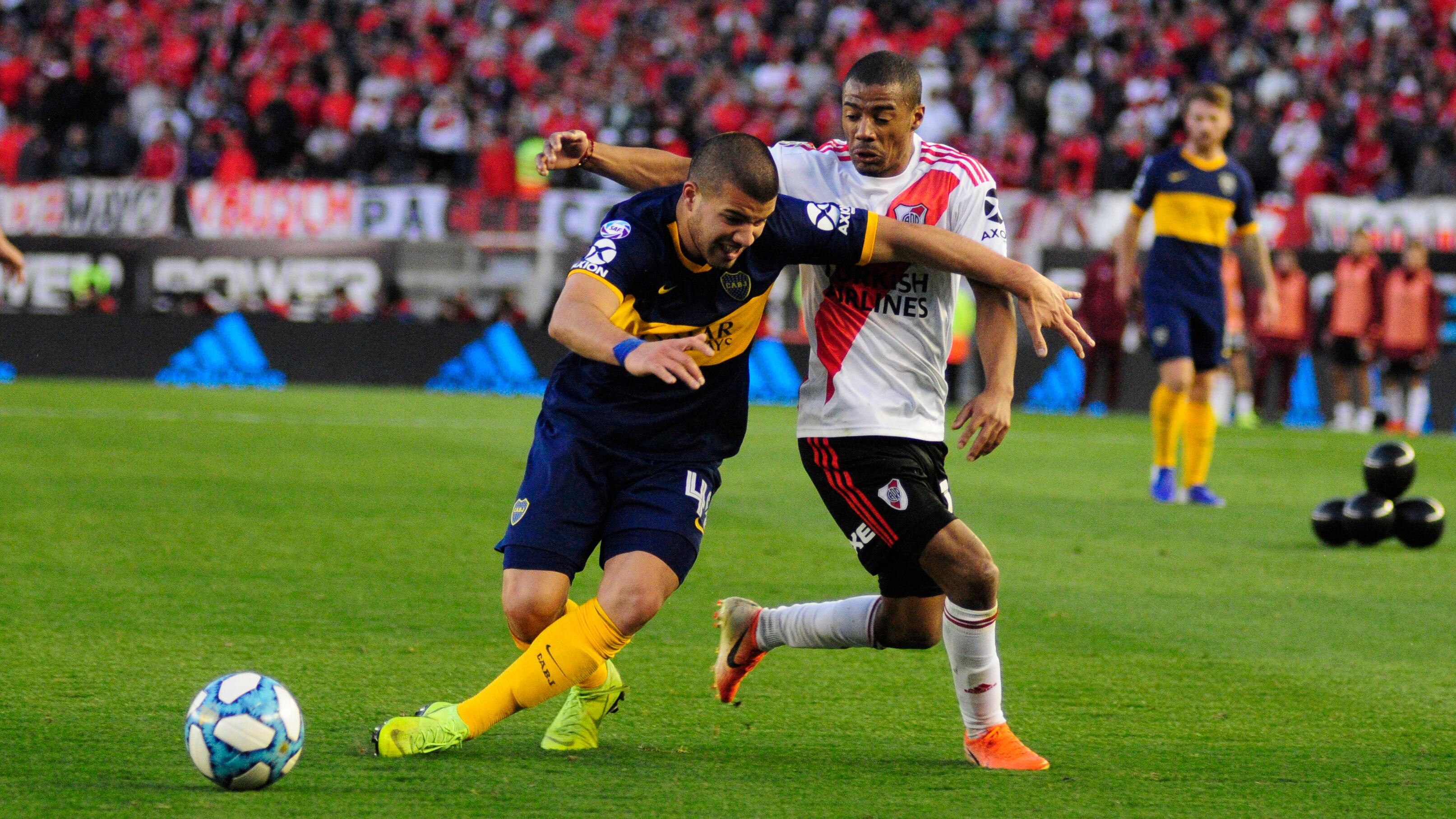 Weingandt y el uruguayo De la Cruz luchan en la mitad de la cancha.