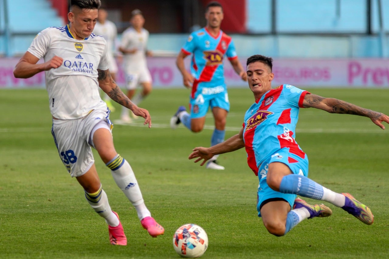 El pibe Luis Vázquez intenta ante la volada de Lucas Suárez