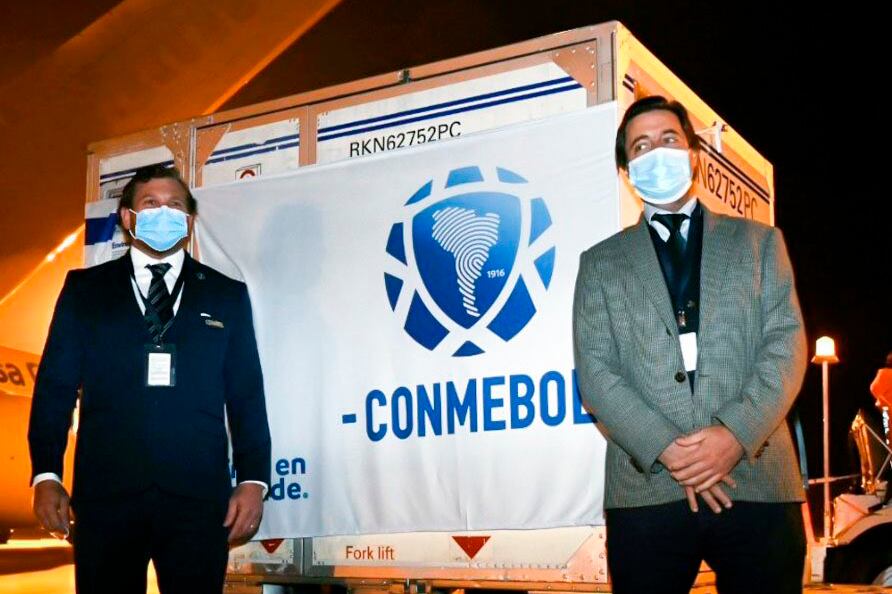 Ronda de fotos entre Domínguez y el presidente de la AUF, con improvisada bandera de la Conmebol incluida