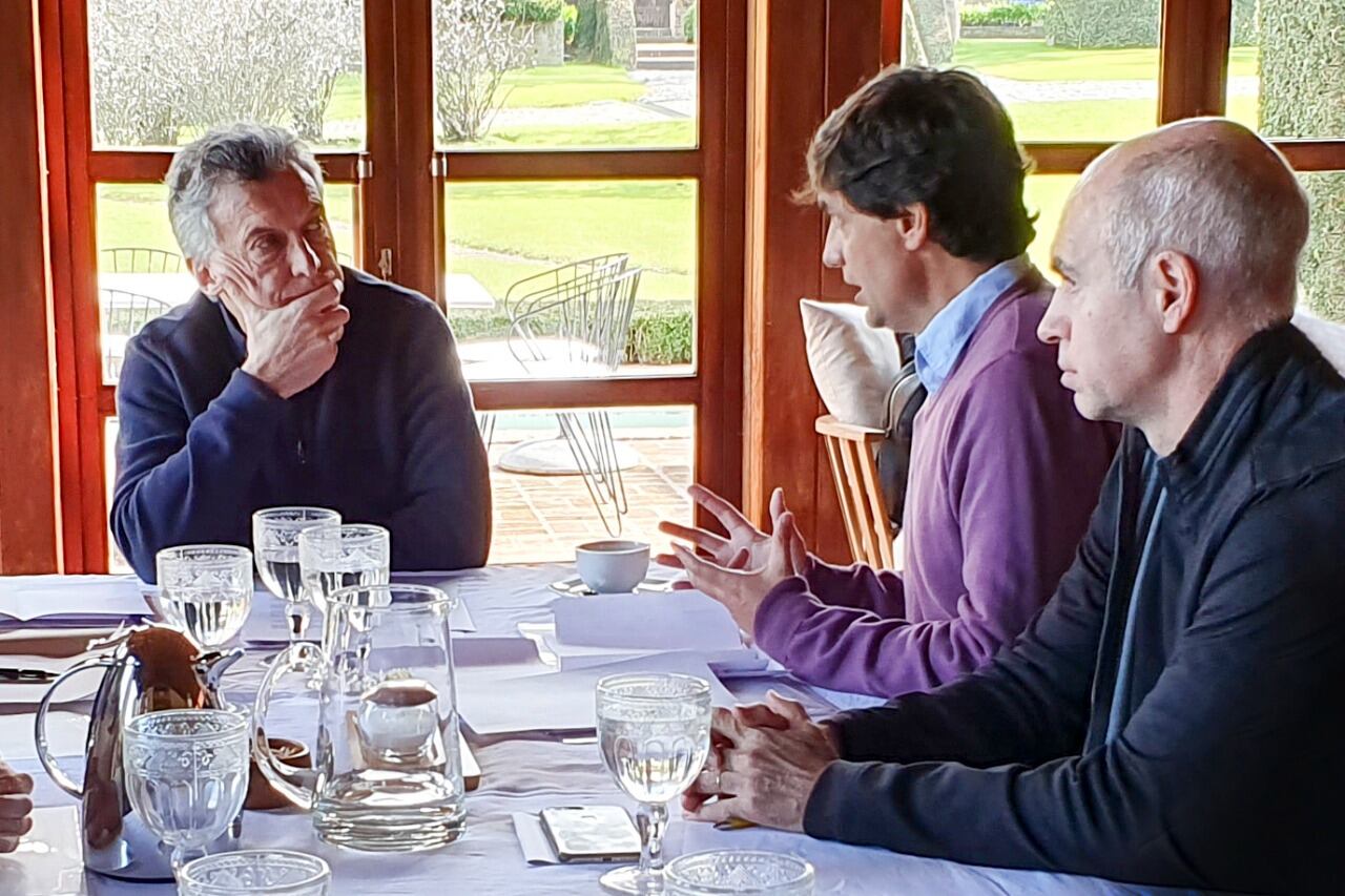 Mauricio Macri escuchando a Hernán Lacunza, jefe del equipo económico del candidato a presidente Horacio Rodríguez Larreta.