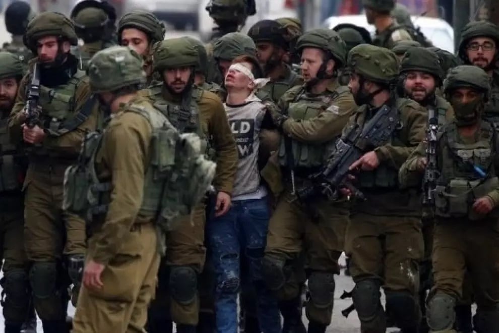  Soldados israelíes detienen a un joven palestino