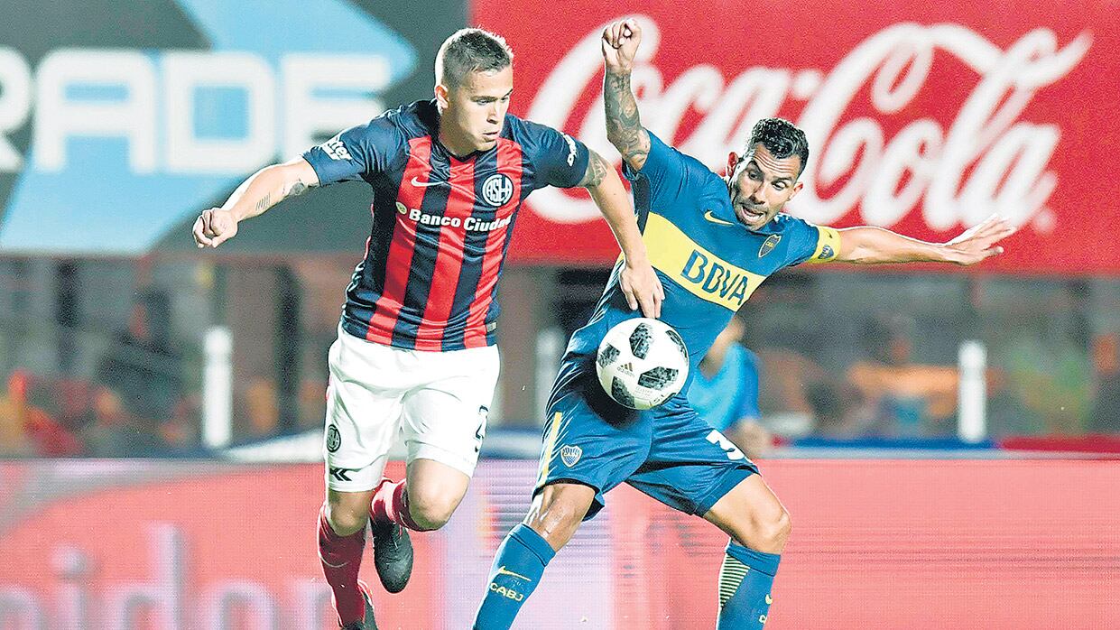 Piris da Motta disputa la pelota con Tevez, que intenta cubrirla.