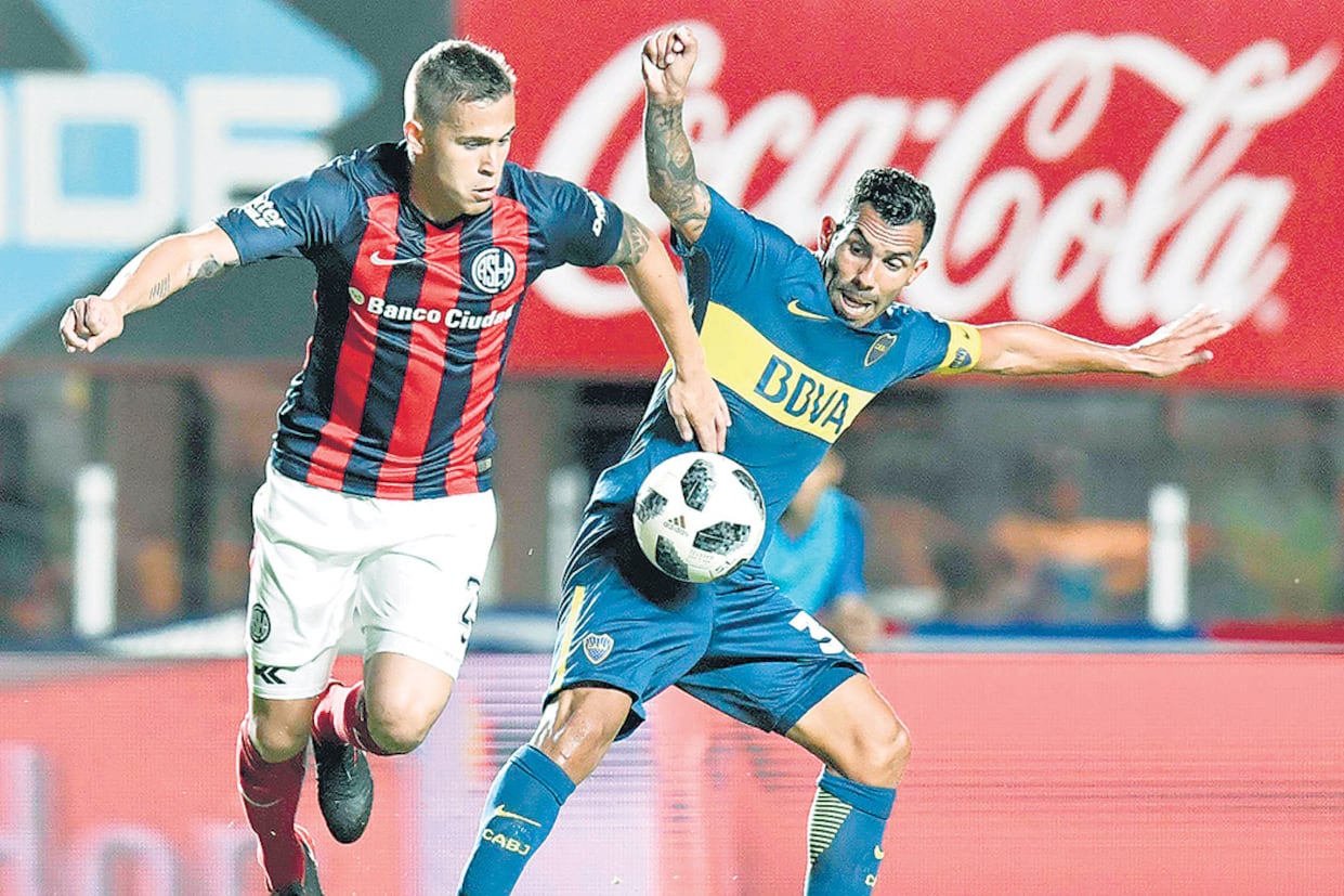 Piris da Motta disputa la pelota con Tevez, que intenta cubrirla.