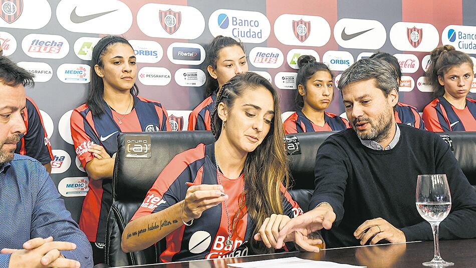 Macarena Sánchez firma su contrato junto al presidente Matías Lammens.