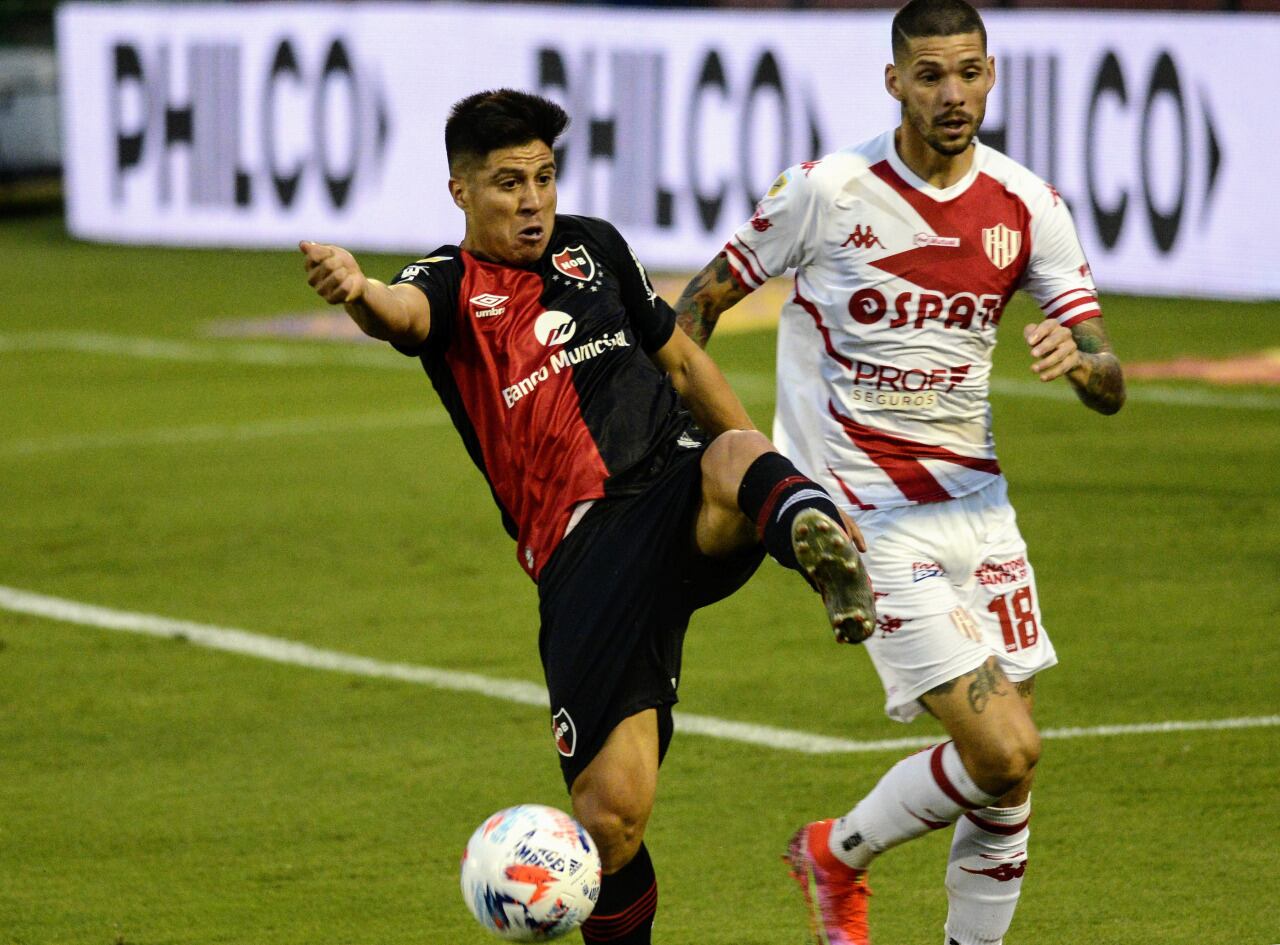 Cristaldo intenta ante Peñailillo. Empató Newell's en el debut de Burgos como DT.