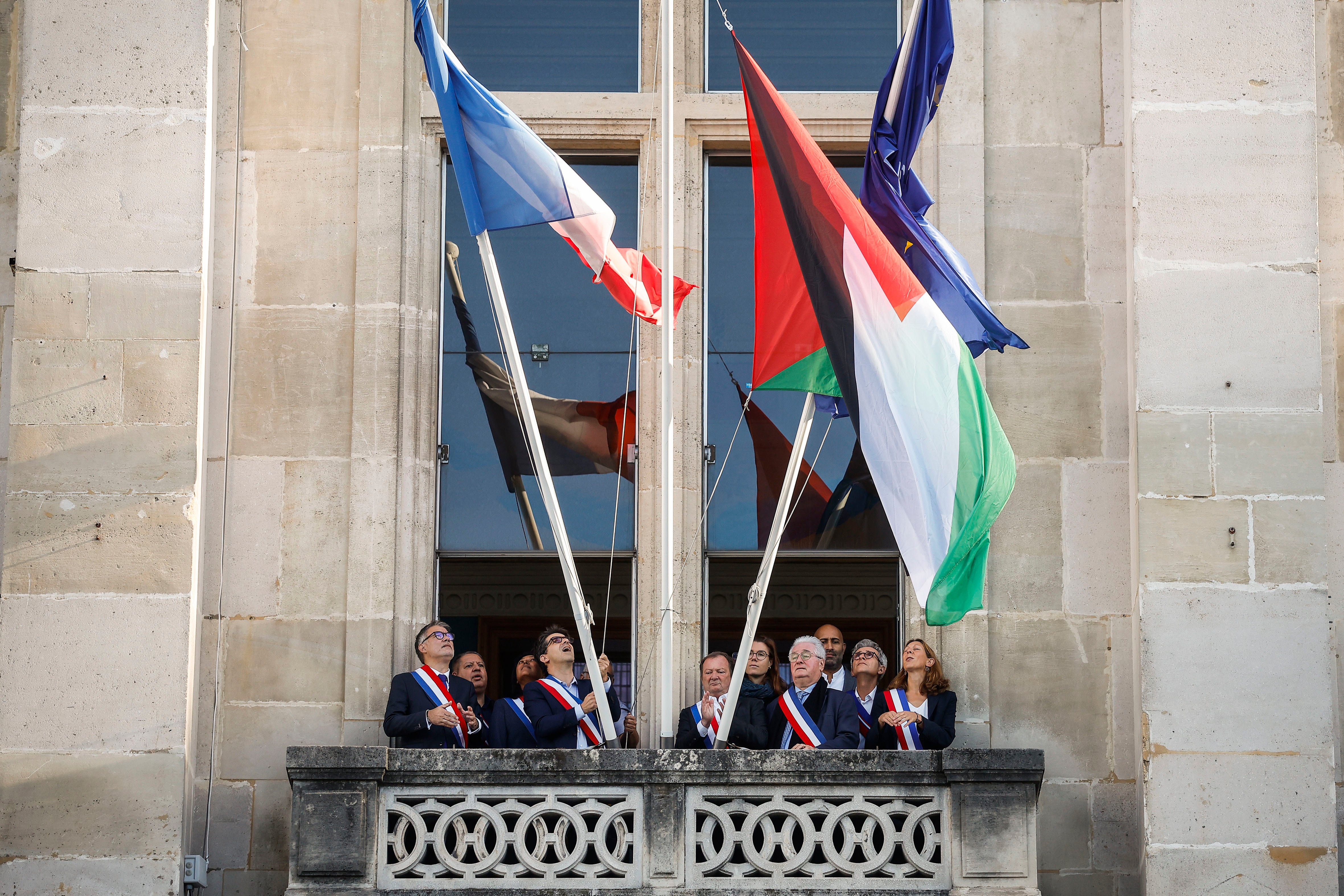 El alcalde de Saint-Denis, Mathieu Hanotin, y el primer secretario del Partido Socialista, Olivier Faure, izan la bandera palestina