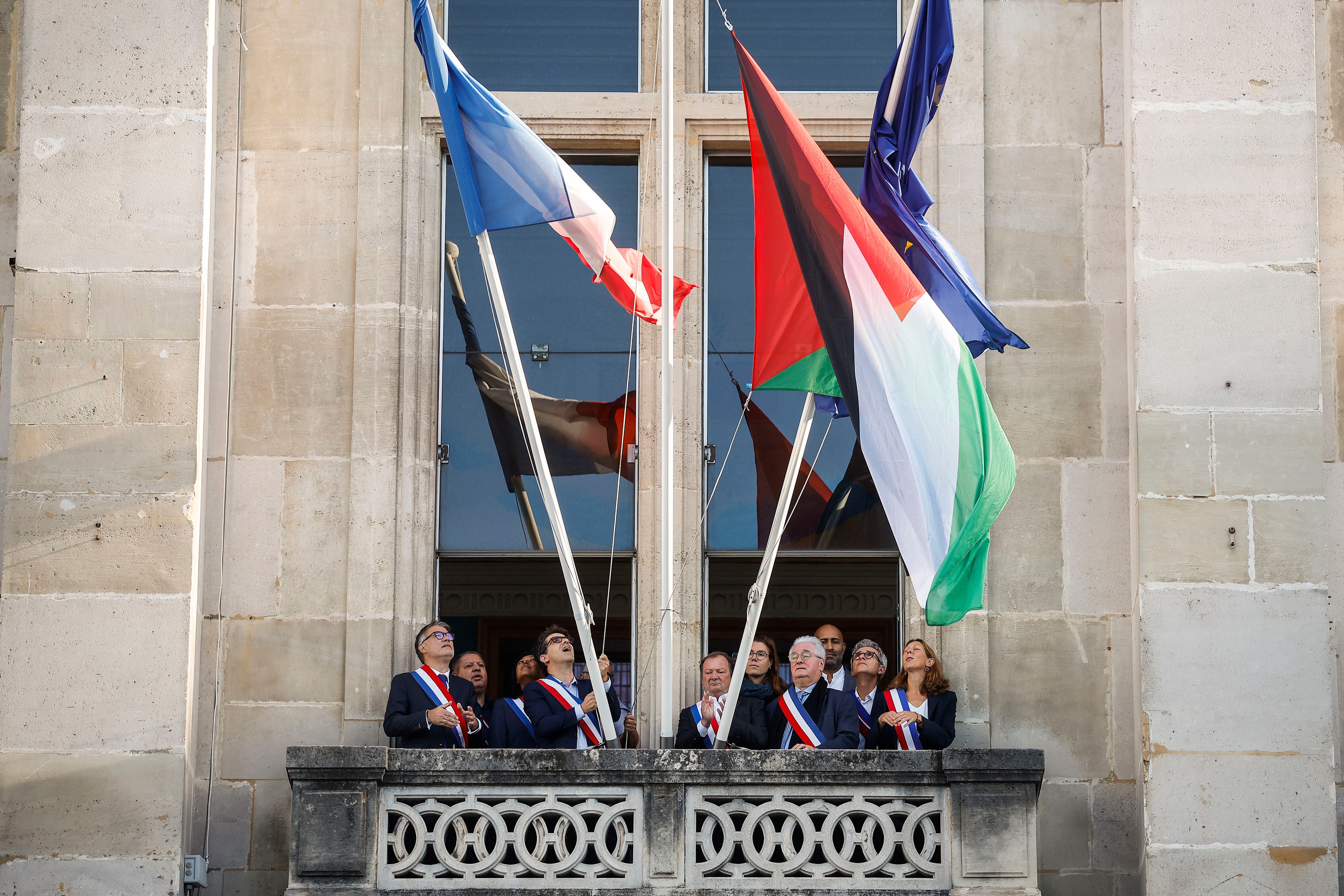 El alcalde de Saint-Denis, Mathieu Hanotin, y el primer secretario del Partido Socialista, Olivier Faure, izan la bandera palestina