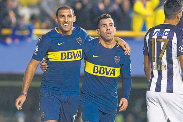 El abrazo de Abila con Tevez, festejando el segundo gol del delantero cordobés en la noche de la Bombonera.